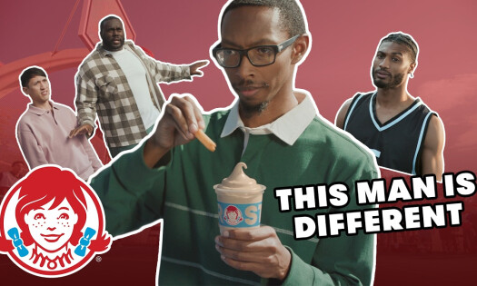 A man dunking his fries into his frosty