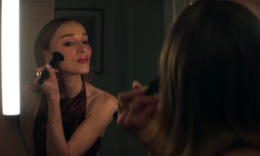 A woman putting on make up in front of the mirror