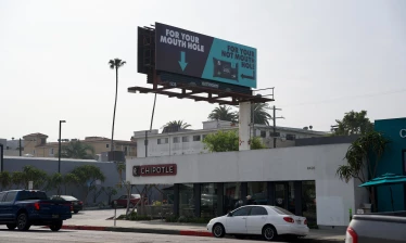 DUDE Wipes' campaign billboard above an LA Chipotle location, reading "For Your Mouth Hole, For Your Not Mouth Hole"