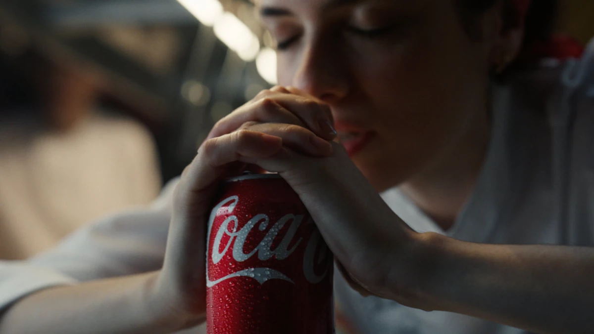 A woman praying over her Coca-Cola can