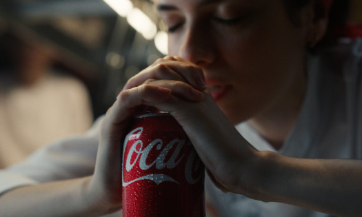 A woman praying over her Coca-Cola can