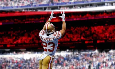 McAffrey with his back to the camera as he jumps up to catch a football with U.S. Bank's signature red stripe