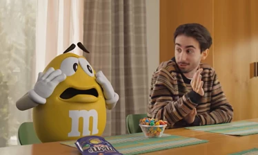 The yellow M&M talking to a man