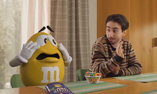 The yellow M&M talking to a man