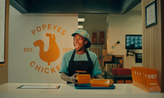 A Popeyes server behind the counter singing