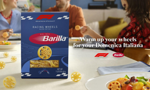 Barilla Racing Wheels pasta packaging on a dining table, with wheel-shaped pasta pieces and a plated dish, highlighting the brand’s Formula 1-inspired design and race-day dining concept.