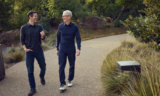 Tim Cook and John Ternus walking and talking together at what seems like a park's pathway