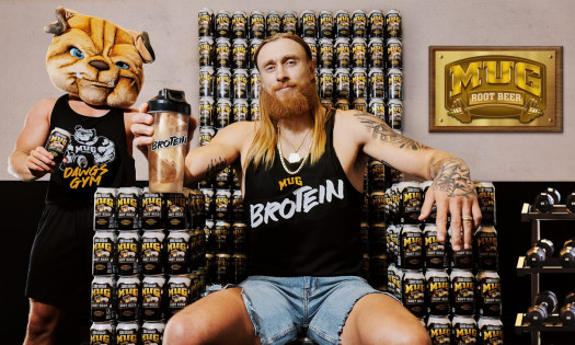 George Kittle sitting on cans of MUG Root Beer