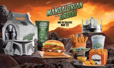 Burger King Star Wars-themed meal featuring a Whopper, chicken fries, nuggets, and a blue shake, displayed with Mandalorian and Grogu packaging against a desert-style backdrop promoting the film’s May 22 release.