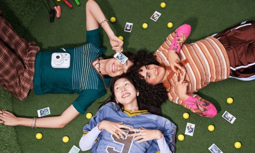 Three friends lying down on grass