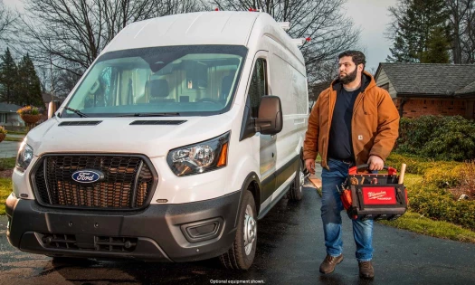 Worker standing next to white Ford van.