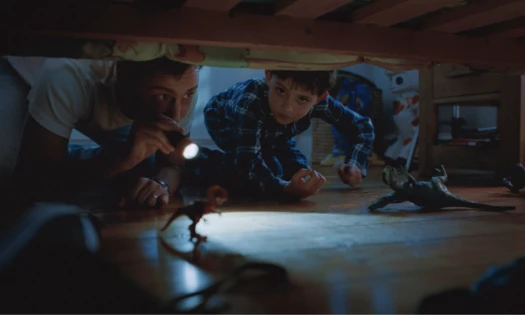Two kids looking under their bed