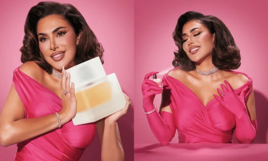 Huda Beauty campaign image for Easy Bake Intense Eau de Parfum, showing the fragrance bottle and oversized Easy Bake-inspired packaging against a pink backdrop.