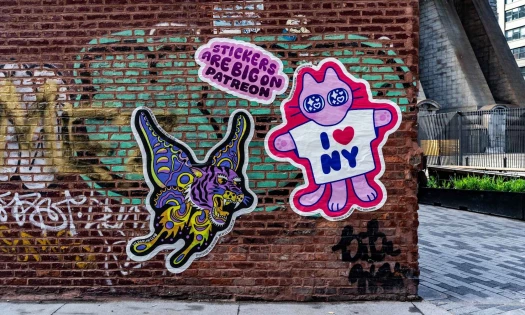 Patreon sticker creations plastered on a street wall.