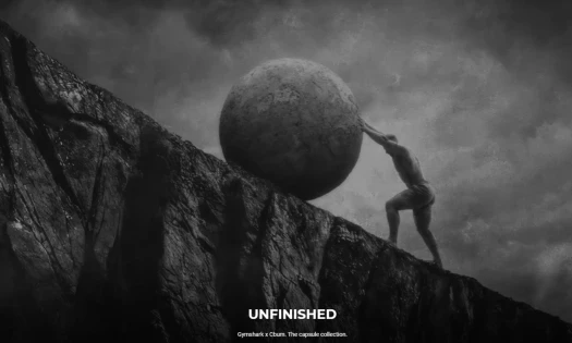 Chris Bumstead pushing boulder up mountain in black and white campaign image for Gymshark x CBum "Unfinished" capsule collection