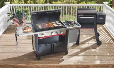 Weber Grill on outdoor deck with American flags in a potplant.