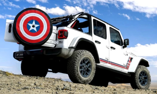 2026 Jeep Wrangler America250 edition with Captain America shield spare tire cover on rocky terrain