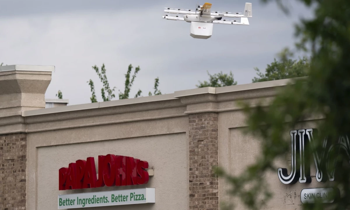 A Wing drone flying over a Papa Johns restaurant.