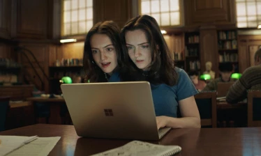 Identical twins use their Windows laptop inside a library