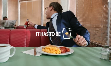 A man borrowing a Heinz bottle from another table