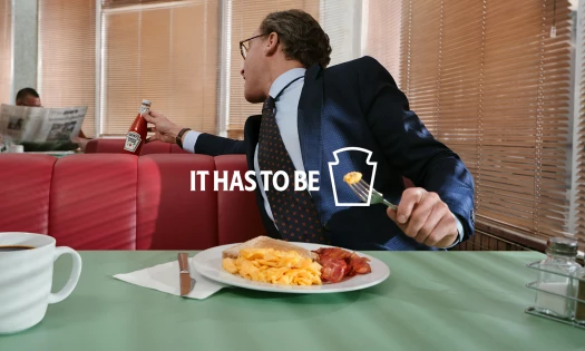 A man borrowing a Heinz bottle from another table