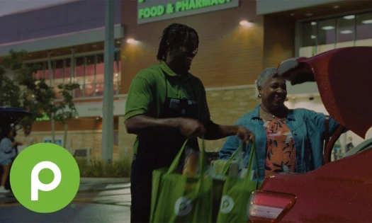 Publix employee helping a customer in the parking lot outside a Publix store.