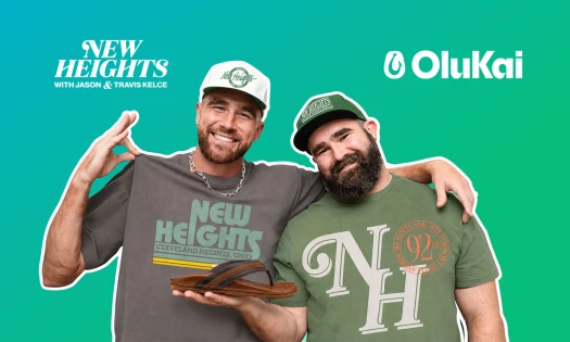 Travis and Jason Kelce in New Heights merch. Jason is holding an OluKai sandal. The brand logos sit in either top corner.