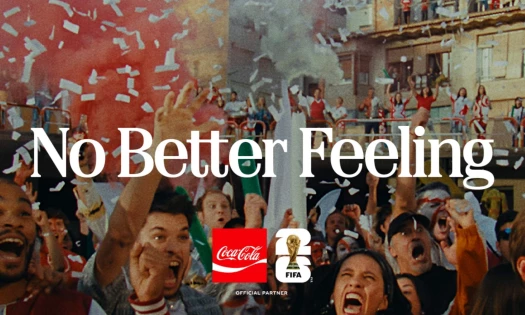 Chaotic fan celebrations in a crowded residential street. "No Better Feeling" is written across in white, with the FIFA World Cup 26 and Coca-Cola logos below it.