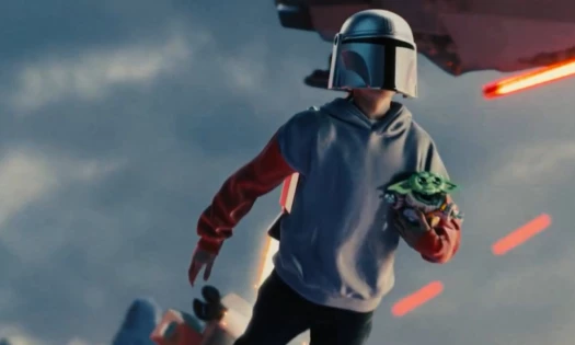 A kid wearing a Star Wars helmet and carrying his Grogu plushie
