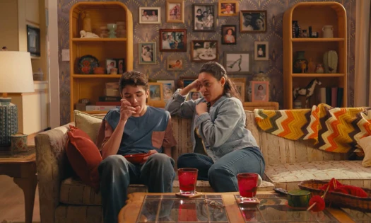 Two kids sitting on a couch in a living room