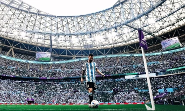 Lionel Messi stands near the corner flag inside a packed World Cup stadium.