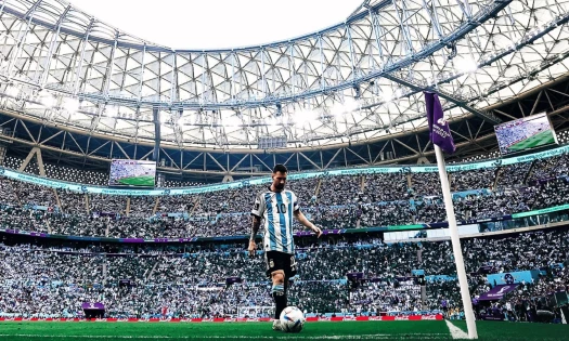 Lionel Messi stands near the corner flag inside a packed World Cup stadium.