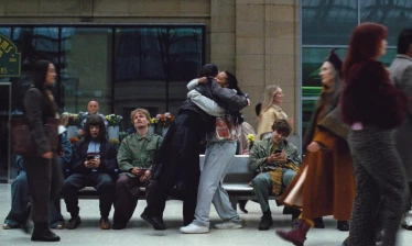 Two people hug in a train station
