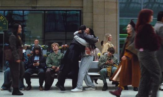 Two people hug in a train station