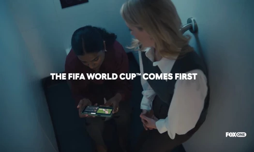 Two women hiding inside a cubicle to watch football