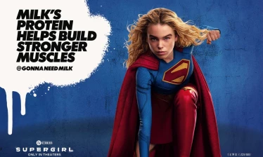 Supergirl in a power pose with "Milk's protein helps build stronger muscles" - @GonnaNeedMilk headline.
