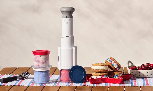 Cuisinart’s FastFreeze 250th Celebration Ice Cream Maker sits beside red, white, and blue frozen treats, ice cream sandwiches, and cherries.