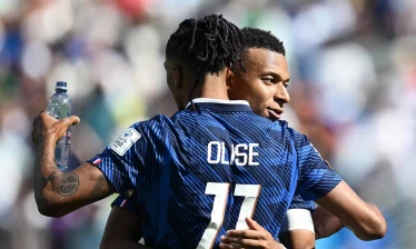Olise holding a bottle of water during one of the game's hydration breaks