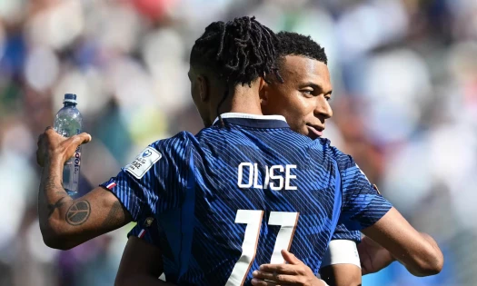 Olise holding a bottle of water during one of the game's hydration breaks