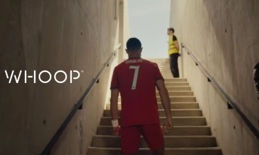 Cristiano Ronaldo in his Portugal football jersey climbing stairs and the WHOOP logo to the left.