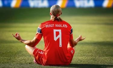Back shot of Erling Halaand in Norway home kit and his man bun matching red KKNEKKI hair tie.