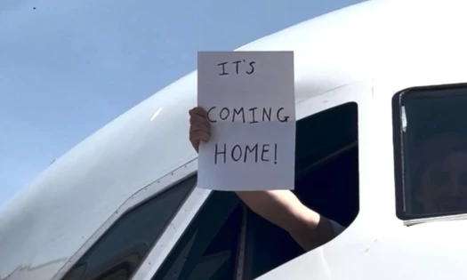 A man holding out a sign that reads "It's Coming Home"