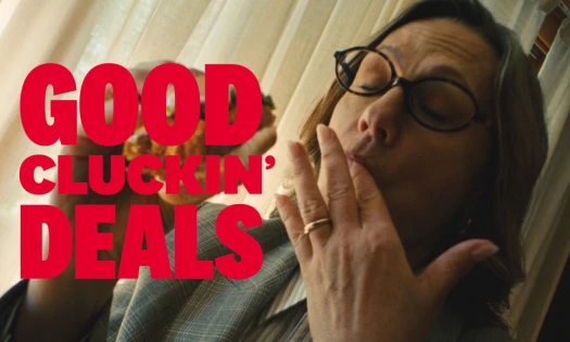 A woman licking her fingers while eating a KFC Zinger