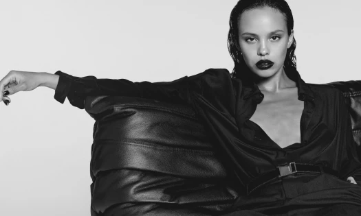 Black and white photo of Alisha Boe on a leather couch.