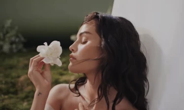Selena Gomez smelling a flower