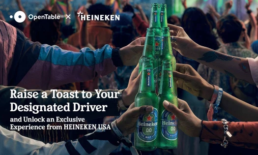 Six people toasting HEINEKEN 0.0 with a party going on in the background.