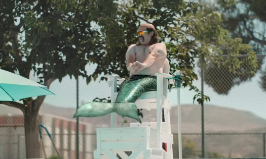 A Merman on duty by the pool