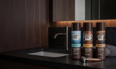 Every Man Jack's 8H Moisture Shave Cream product line on a bathroom counter with a towel and shaver.