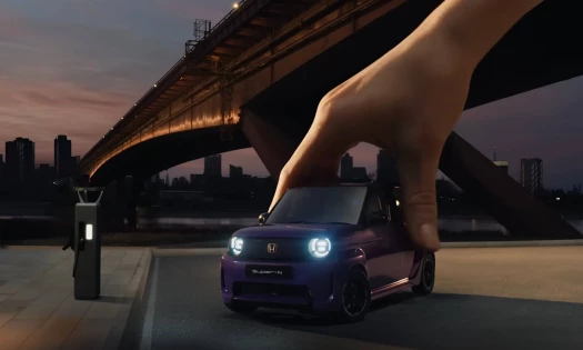 A miniature purple Hnda Super-N with a hand holding it
