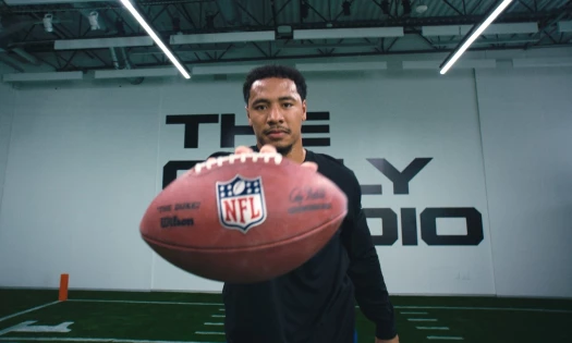 Cam Bynum holds up an NFL football